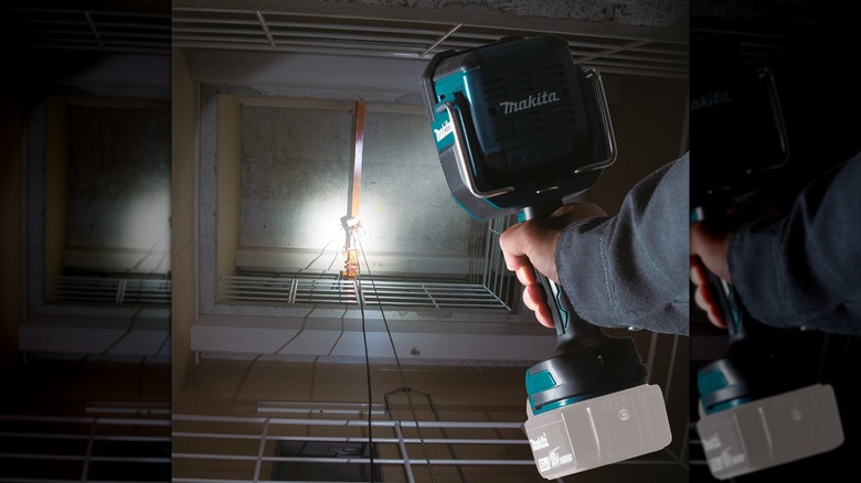 A person using Makita's 18V LXT Lithium-Ion Cordless LED Flashlight/Spotlight