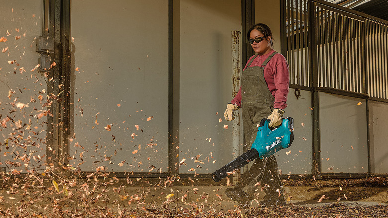 A person using Makita's 36V LXT Lithium-Ion Brushless Cordless Leaf Blower