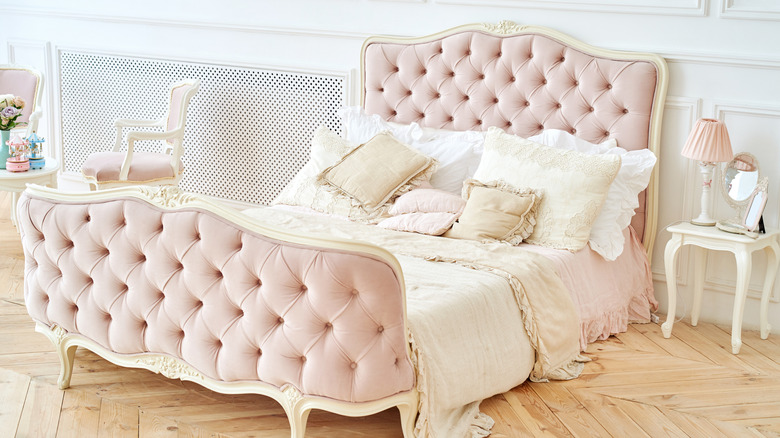 A pink upholstered headboard with matching base board