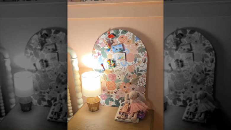 A wallpaper-covered magnet board made from a Hobby Lobby arched metal magnet holder.