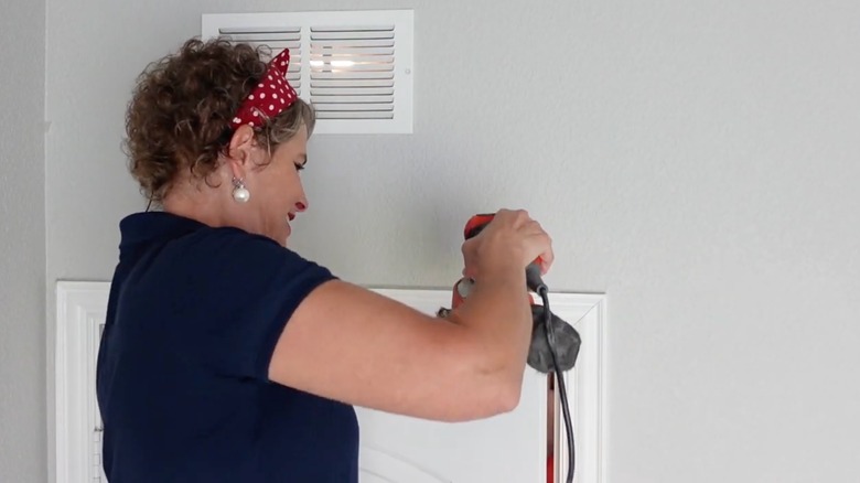 woman sanding top of internal door