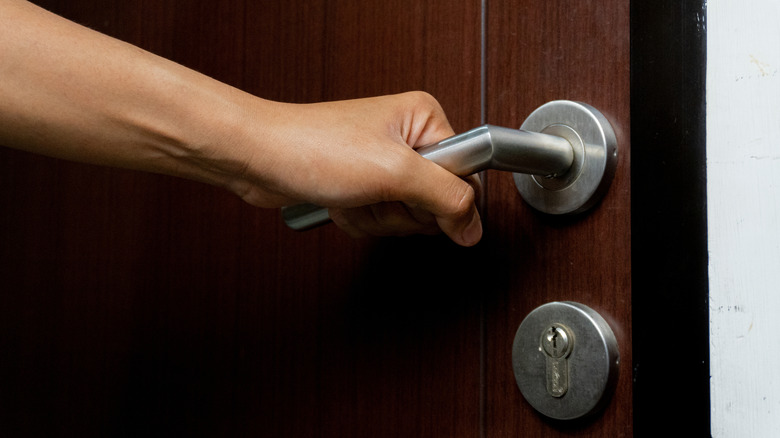 hand opening wooden door close up