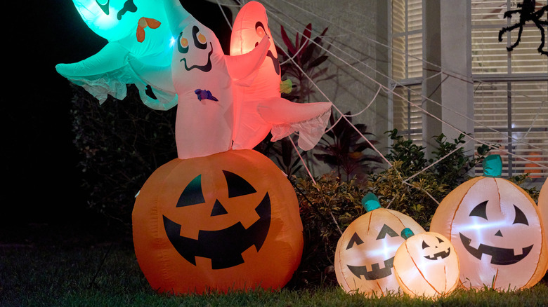 Inflatable ghosts and jack-o-lanterns outside a home on the yard