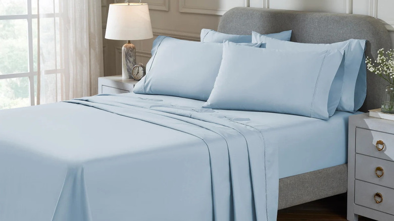 A bed made with blue Therapedic 300 Thread Count 6-piece Peached Percale Sheets