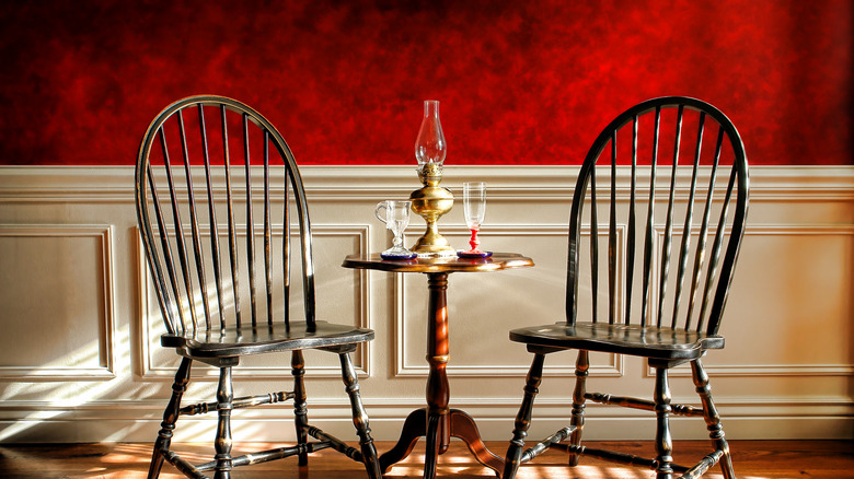 Wood chairs and table in front of a red imitation painted wall finish