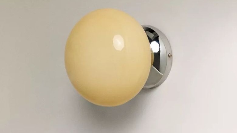 Glass metal wall sconce on wall