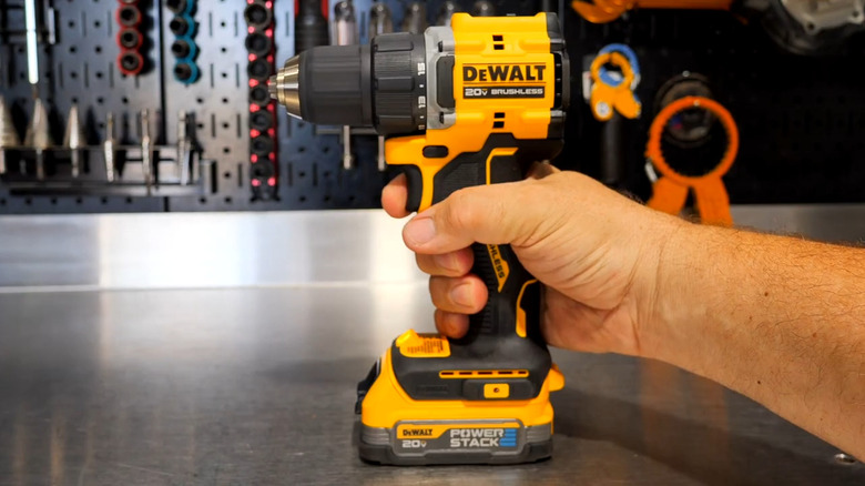 Hand holding a DeWalt Atomic cordless compact drill/driver