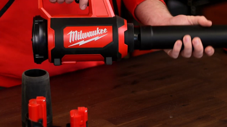 Man in red shirt holding Milwaukee blower