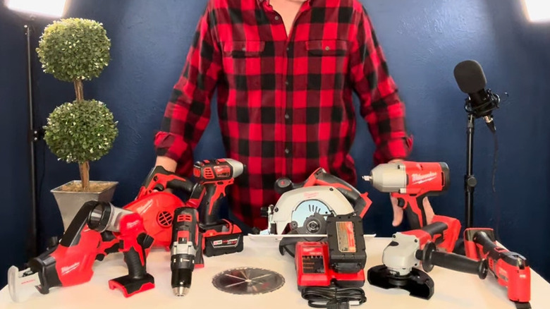 Man with plaid shirt standing behind array of tools in the Milwaukee M18 combo kit