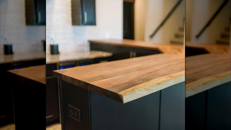 Butcher block with a live edge by Hardwood Reflections sits as the kitchen counter on dark cabinets..