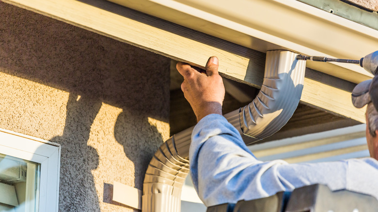 man installing gutters