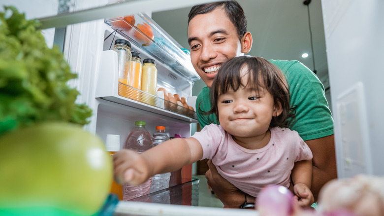 man and toddler opening fridge