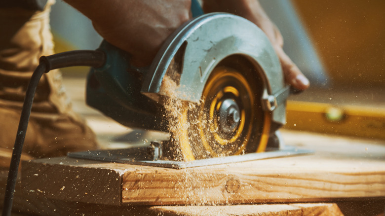 Person cutting with saw