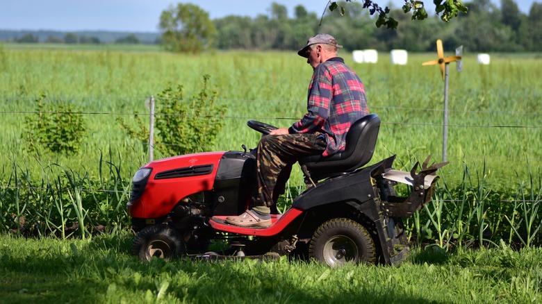 A man cutting grass with a riding mower