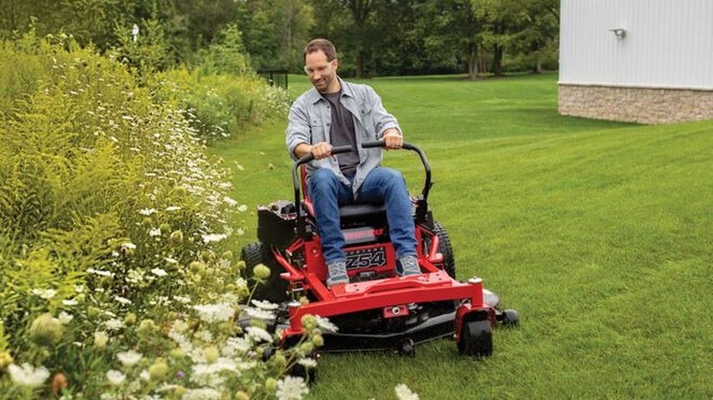 A man on a Troy Bilt Z54 zero-turn riding mower