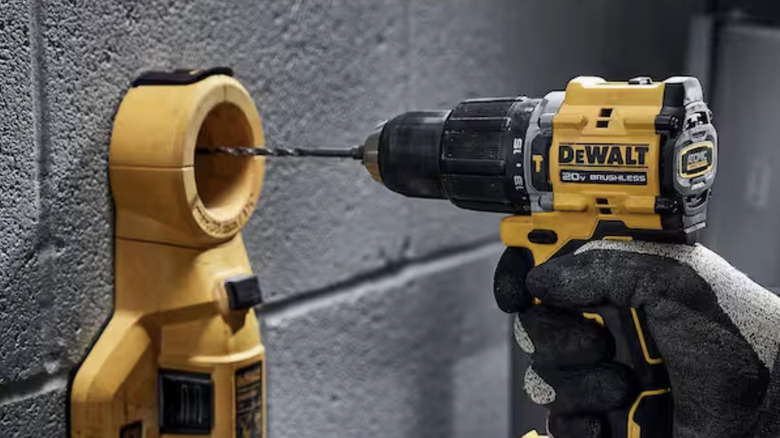 A hand holding a Dewalt hammer drill.