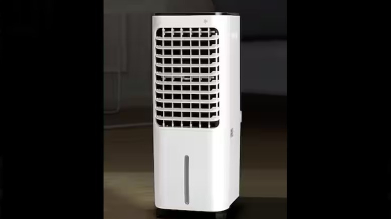 A compact white evaporative cooler cools a room in a home.