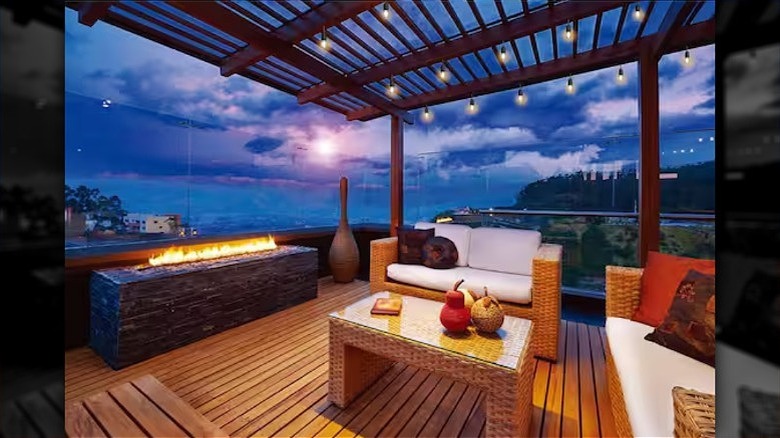 An outdoor living room by lit with string lights by the beach is ready for entertaining.