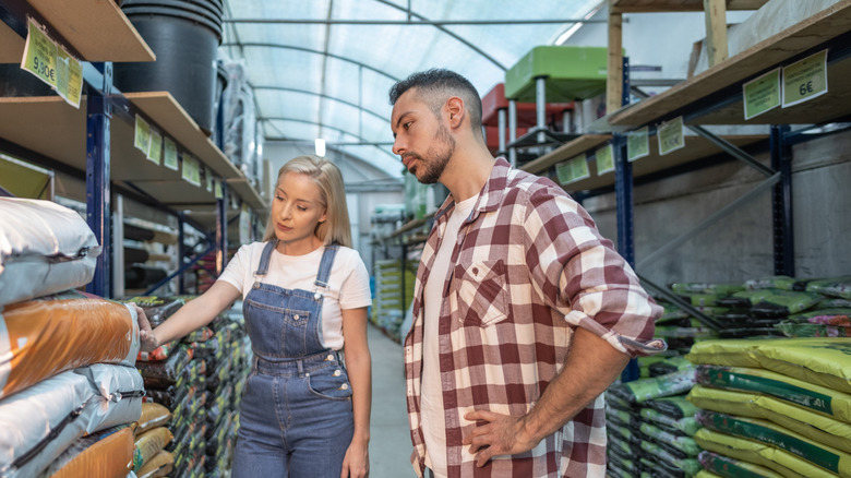Man and woman shopping in garden aisle of home improvement store.