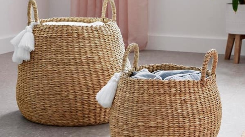 Two woven baskets with white tassels on the handles