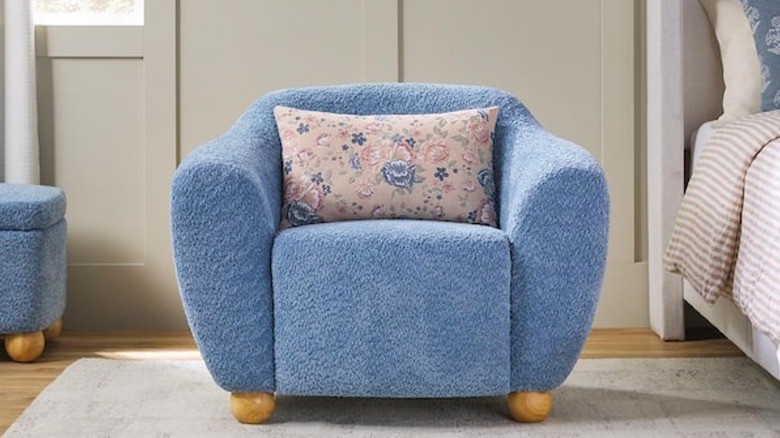 A blue accent chair in a bedroom