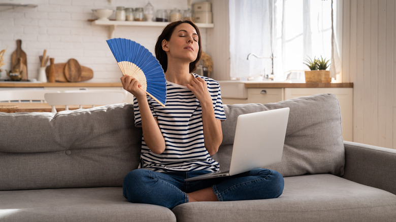 Woman fanning herself on couch