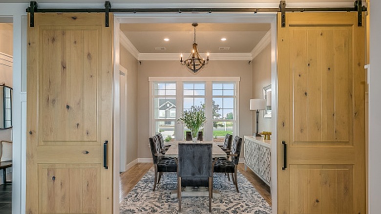 Barn doors hanging in front of a dining room