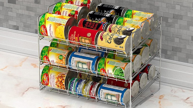 rolling can organizer on stone countertop with canned fruits, soups, and vegetables