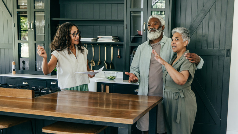 A couple talking with a realtor in kitchen