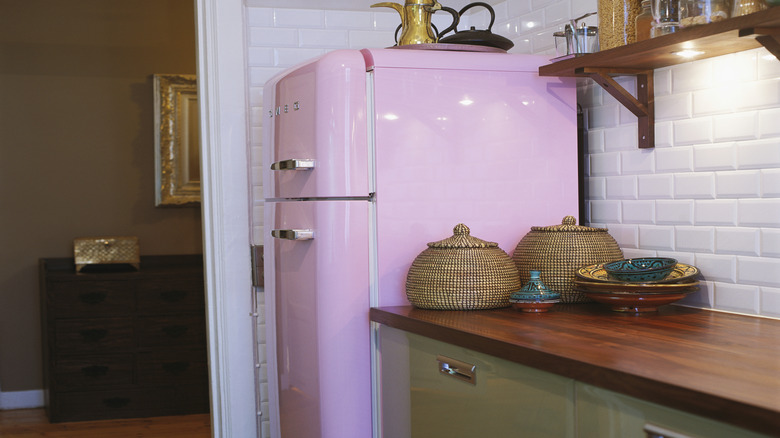 A kitchen with a pink vintage fridge.