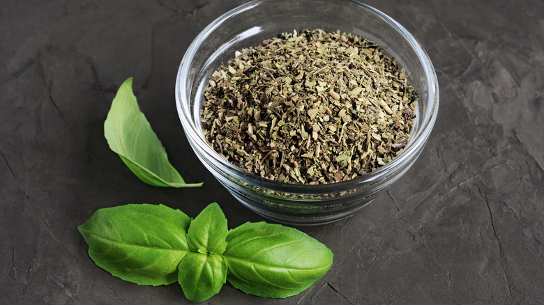 Fresh and dried basil on table
