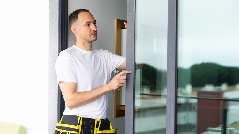 a man replacing sliding glass doors