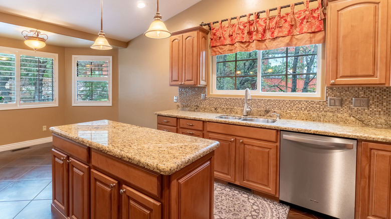 Outdated '90s wood kitchen cabinets and granite countertops