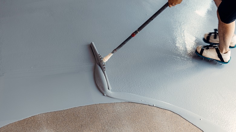 A man applying epoxy on a residential garage floor