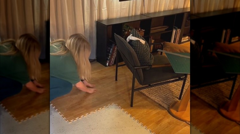 Woman putting down wood foam tiles to help make basement more welcoming