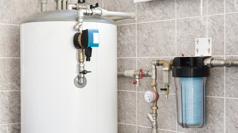 A house water heater with pump hung on tiled wall