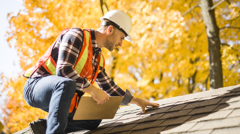 Man inspecting a home's roof