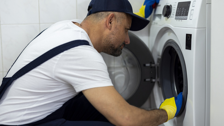 Repair person working on a clothes dryer