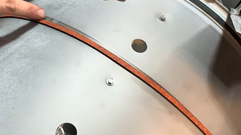 Person replacing a belt on a dryer drum