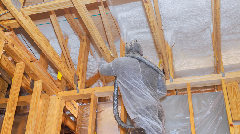 A person installing foam insulation during a renovation.