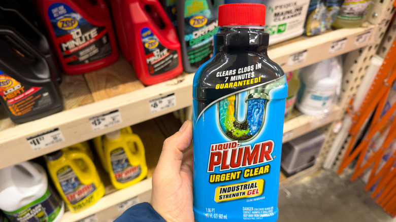 man holding a bottle of drain cleaner