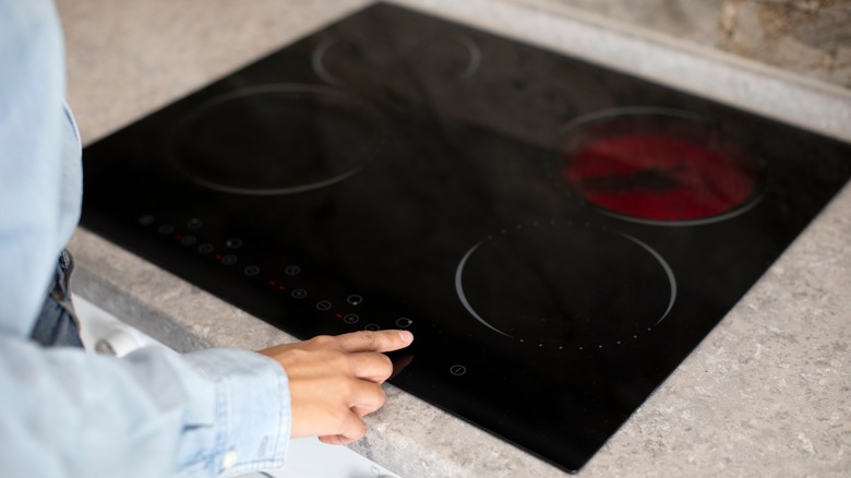 person using touch screen on induction stove