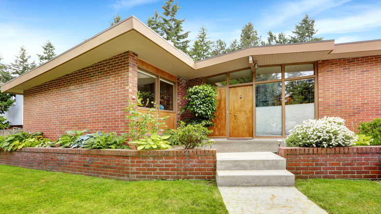 The exterior of a brick mid-century house.