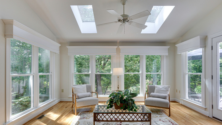 Bright sunroom in house with white walls and two armchairs