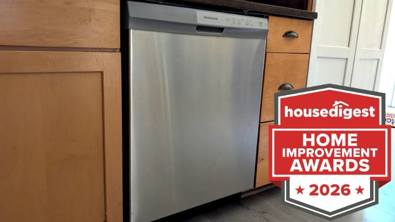 A stainless steel dishwasher in a kitchen with wood cabinets