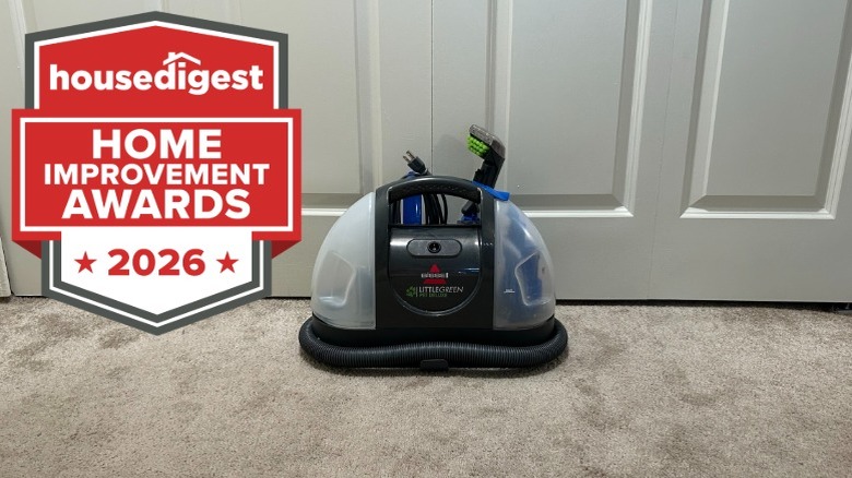 A Bissell floor cleaner sitting on the carpet in front of two doors