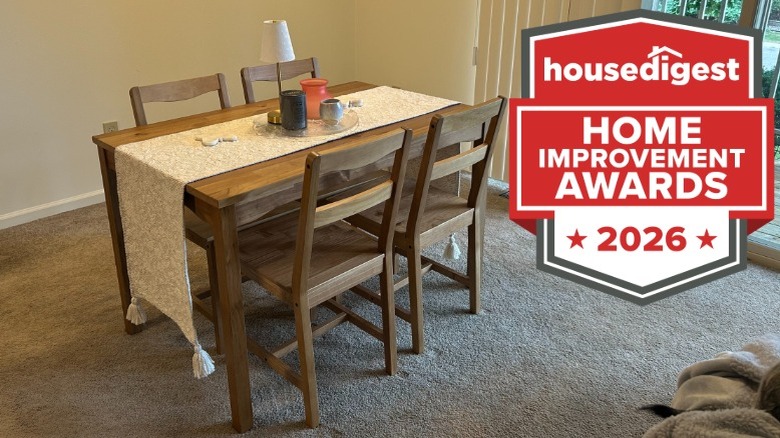 A medium-toned wood dining set in a dining room with carpet
