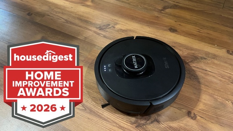 A black Matrix robot vacuum on wood flooring