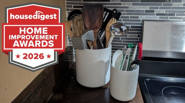 Two white utensil holders holding cooking tools