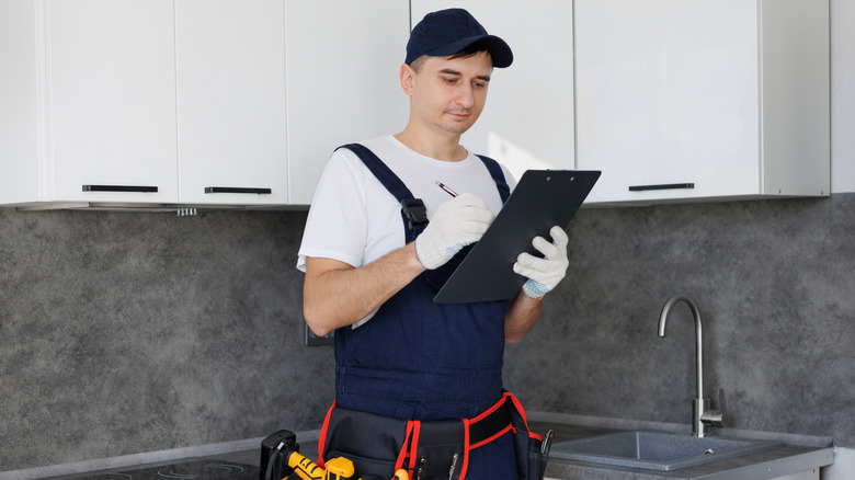 A repairman in a kitchen